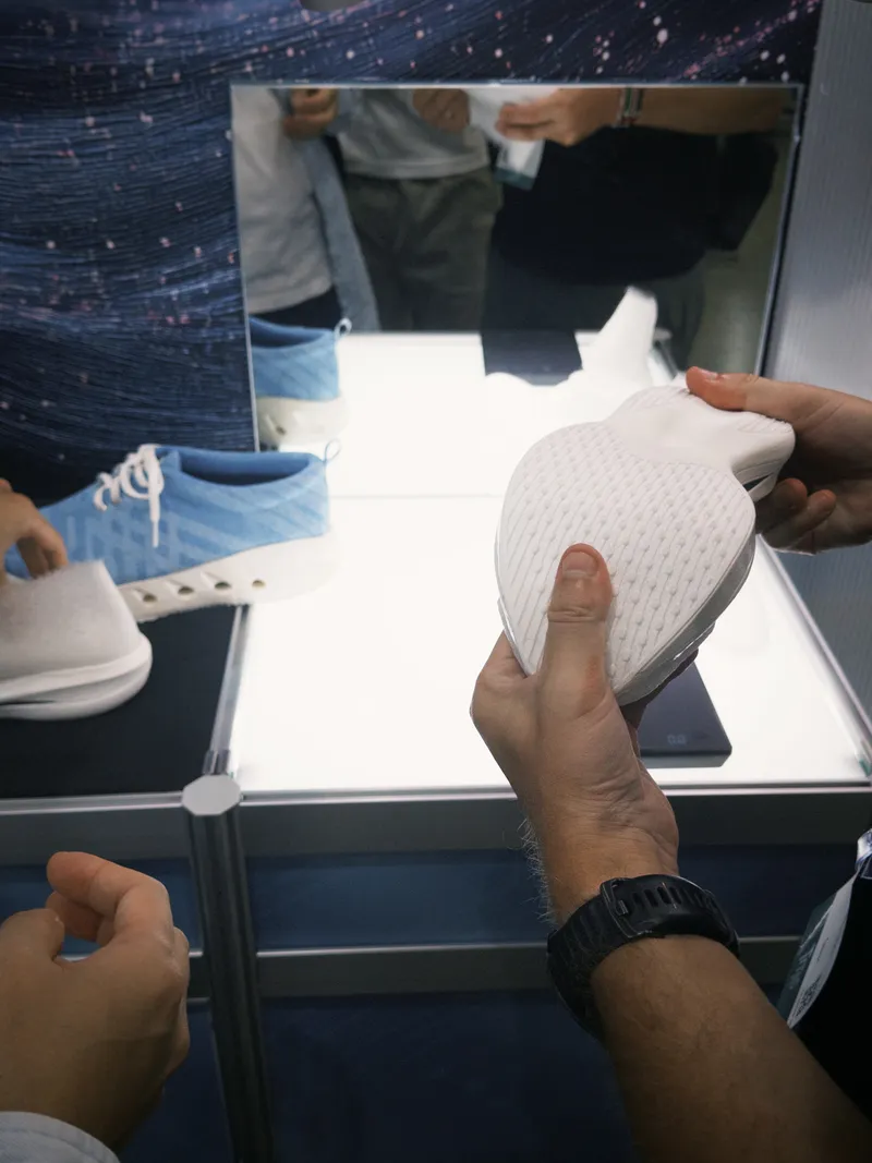 Hands holding a shoe at a design fair