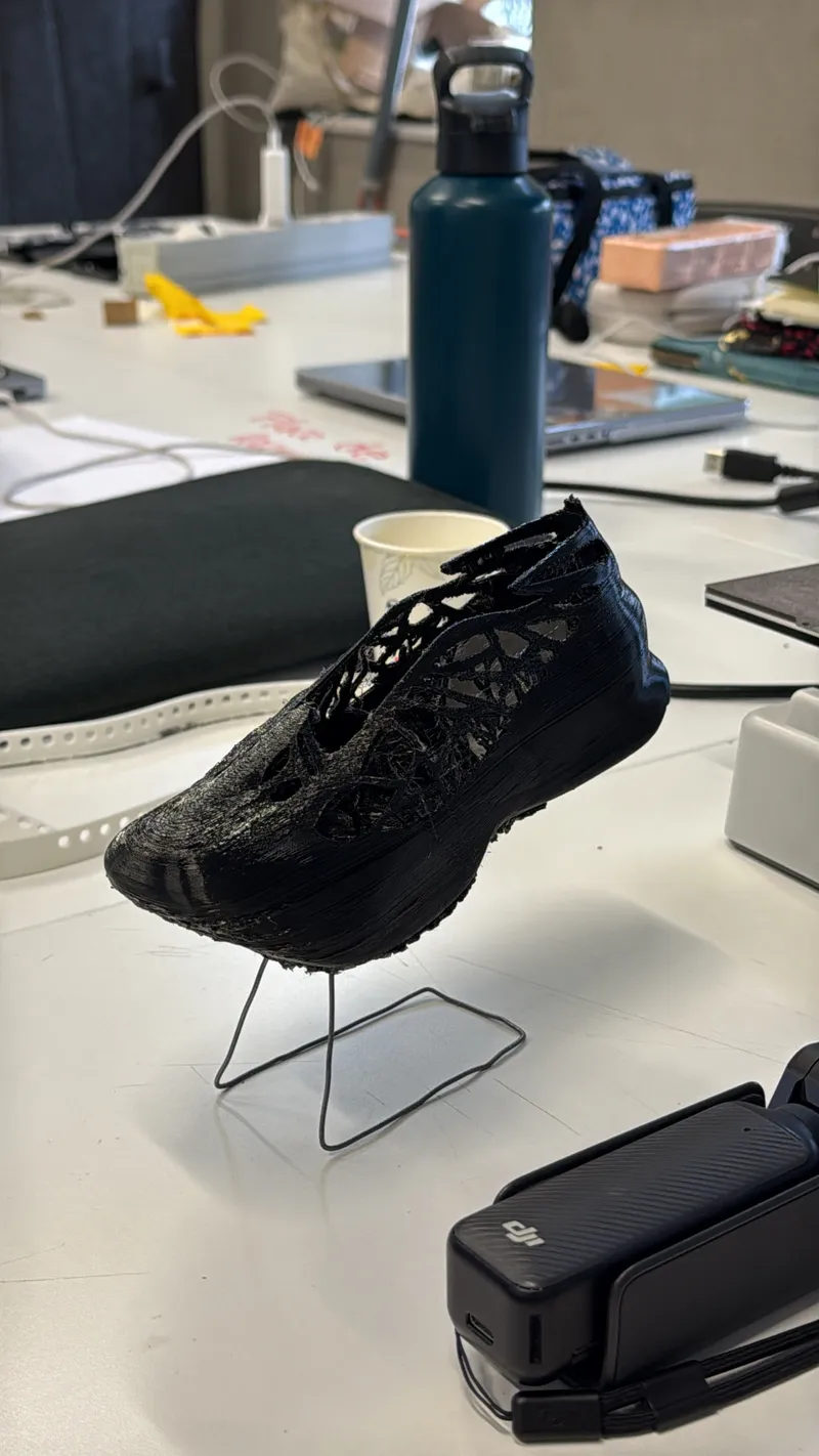 Black shoe prototype on a stand in a workshop