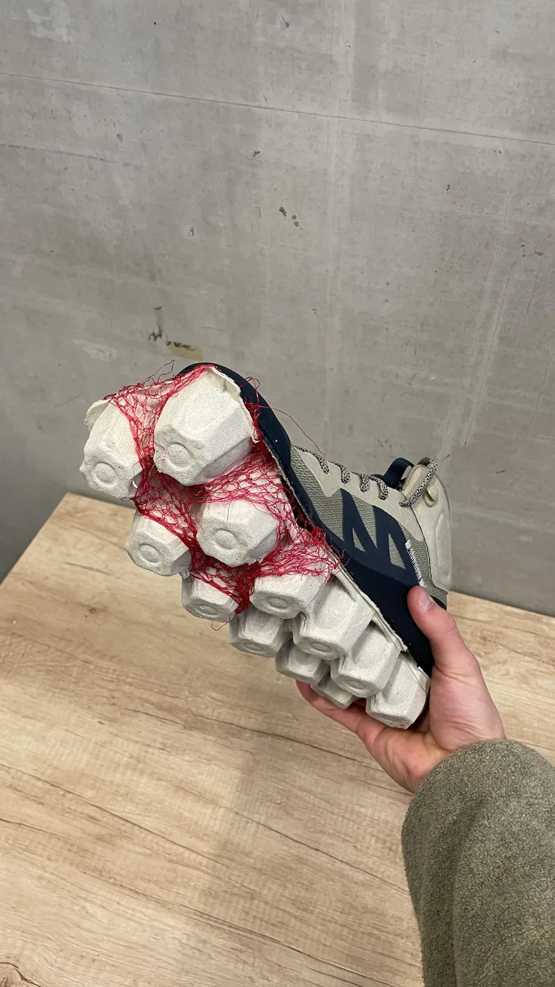 Shoe prototype held against a concrete wall